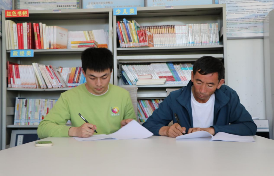 图为实践团指导老师王健与二连村党委书记王生玉签订实践教育基地协议
